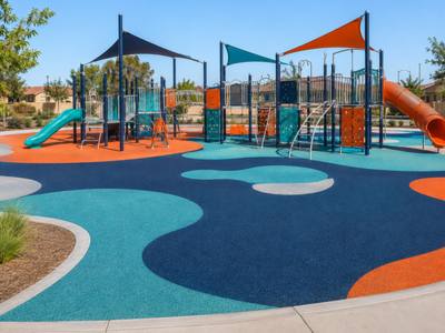Community playground in blue and orange rubber surfacing