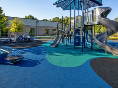 Blue rubber playground surfacing under a slide